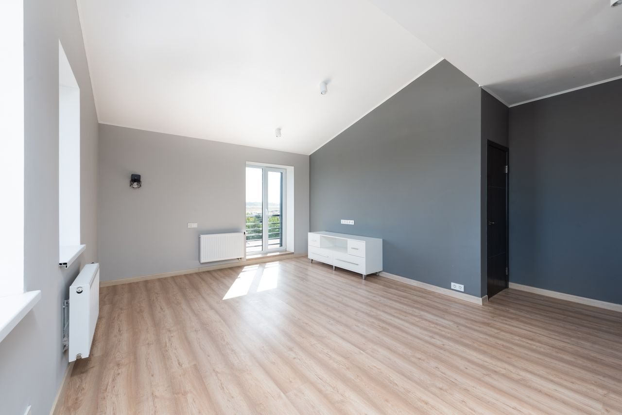 Full living room home renovation with modern wall paneling, hardwood flooring, and minimalist furniture