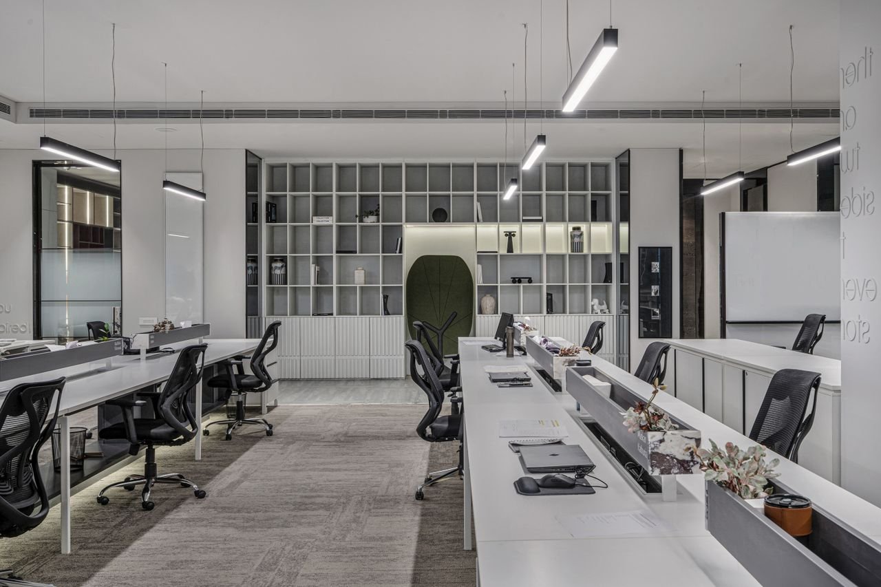 Modern office renovation featuring open plan workstations, ergonomic desks, and updated ceiling lighting