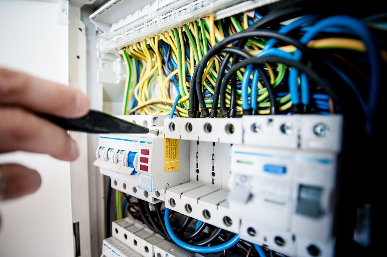 Licensed electrician performing commercial and residential electrical panel wiring and maintenance.